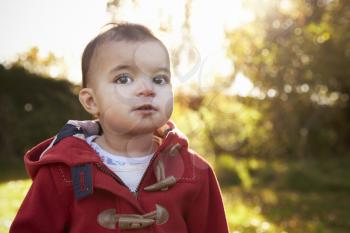 Portrait Of Young Girl Standing In Autumn Garden