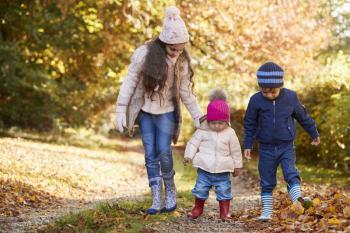 Three Children Enjoying Autumn Countryside Walk Together