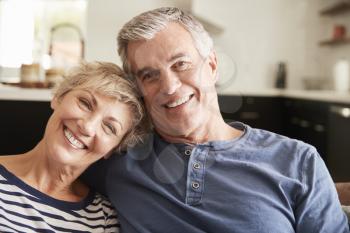 Senior couple relaxing at home smiling to camera, close up