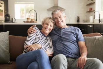 Senior white couple relaxing at home smiling to camera