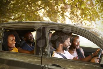 Two black adult couples in a car during a road trip
