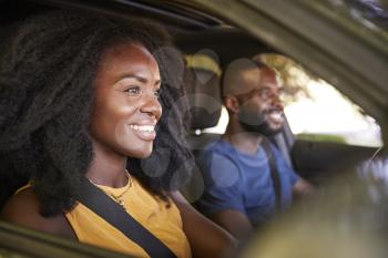 Young black couple smiling in a car during a road trip