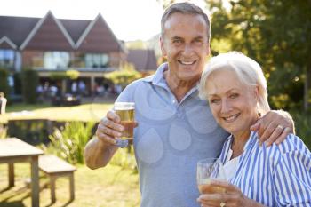 Portrait Of Senior Couple Enjoying Outdoor Summer Drink At Pub
