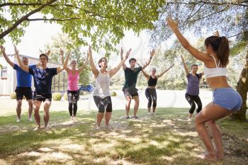 Female Instructor Leading Outdoor Yoga Class