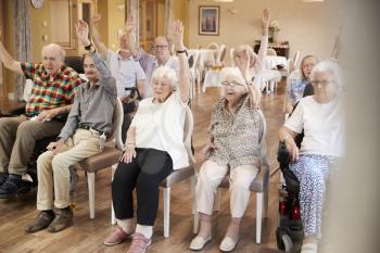 Group Of Seniors Enjoying Fitness Class In Retirement Home