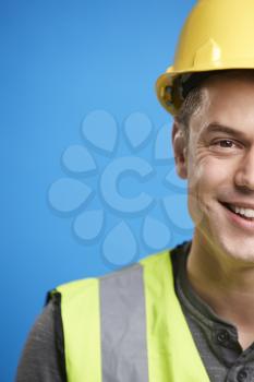 Smiling young construction worker in hard hat, vertical crop