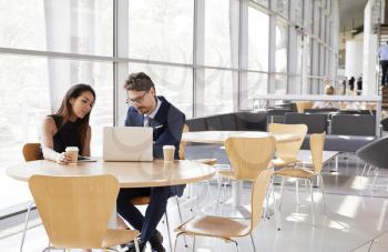 Businesswoman and businessman looking  at laptop