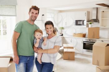 Portrait Of Family With Baby On Moving In Day