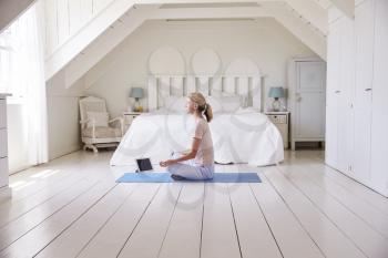 Woman With Digital Tablet Using Meditation App In Bedroom