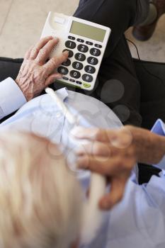 Senior Man At Home Using Telephone With Over Sized Keys