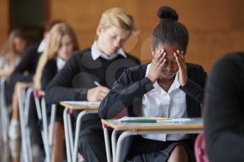 Anxious Teenage Student Sitting Examination In School Hall