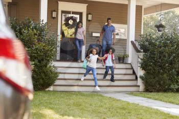 Family With Luggage Leaving House For Vacation