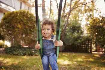 Happy Young Girl Playing On Garden Swing