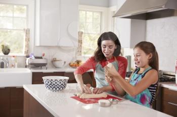 Jewish mother and daughter preparing dough for challah bread