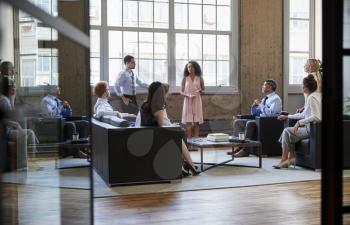 Informal business meeting seen through open glass doors