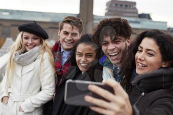 Group Of Young Friends Taking Selfie On Winter Visit To London