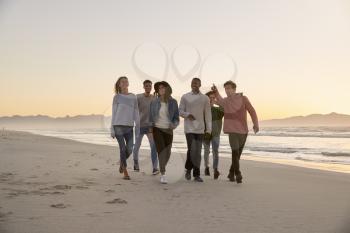 Group Of Friends On Walking Along Winter Beach Together