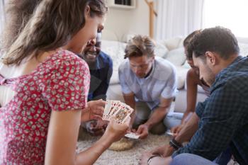 Group Of Friends At Home Playing Cards Together