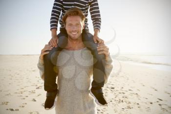 Detail Of Father Carrying Son On Shoulders On Winter Beach
