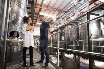 A male and a female technician talking at a wine factory