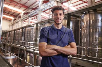 Portrait of a young Hispanic man working at a wine factory