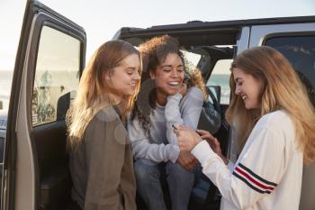 Girlfriends planning road trip with tablet computer by car