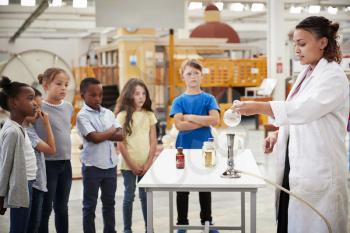 Kids watching lab technician carry out a science  experiment