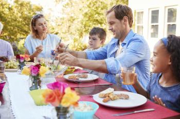 Friends and family having lunch at a table in the garden