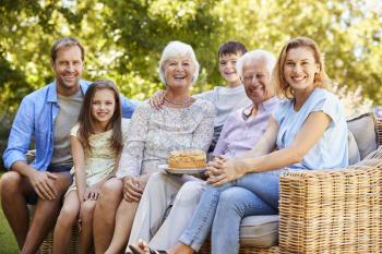 Three generation family sitting together in the garden