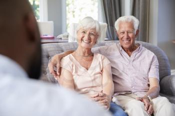 Happy senior couple taking financial advice at home