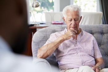 Senior man with depression having therapy with psychologist