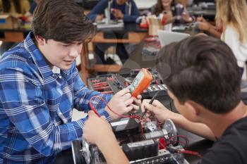 Two Male Pupils Building Robotic Vehicle In Science Lesson