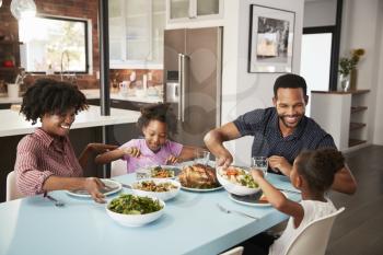 Family Enjoying Meal Around Table At Home Together