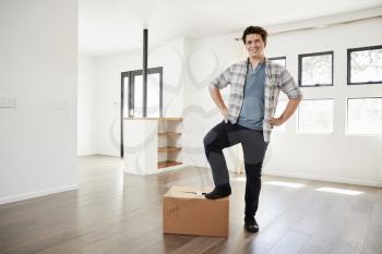 Portrait Of Proud Man Standing On Box In New Home On Moving Day