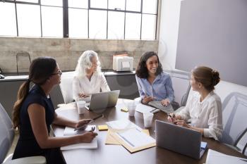 Four businesswomen in discussion in a meeting room