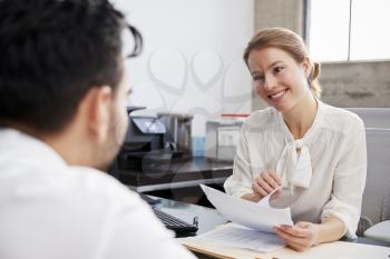 Smiling white female professional in meeting with young man