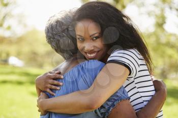Portrait Of Senior Mother With Adult Daughter Hugging In Park