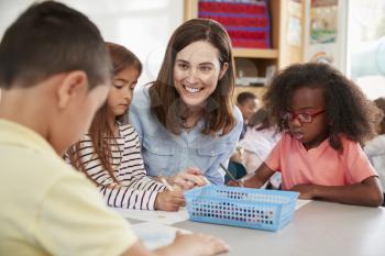 Female elementary school teacher and kids in class, close up