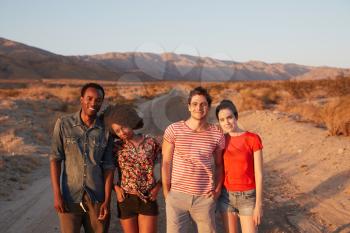 Young adult couples in desert smiling to camera, close up