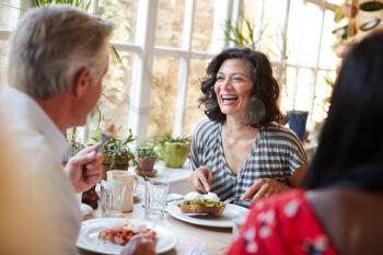 Laughing woman laughing with male friend at a cafe, close up