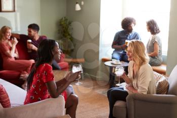 Two female friends having a drink, talking in a pub