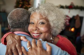 Portrait Of Senior Couple Hugging As They Celebrate Christmas At Home Together