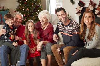 Portrait Of Multi Generation Family Sitting On Sofa In Lounge At Home On Christmas Day