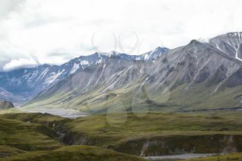 Dry River Bed Running Through Valley Between Mountains In Alaska