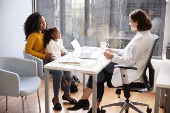 Mother And Daughter Having Consultation With Female Pediatrician In Hospital Office