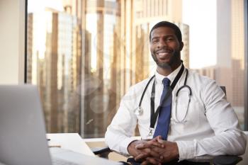 Portrait Of Smiling Male Doctor With Stethoscope In Hospital Office