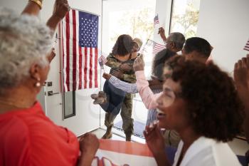 Young black soldier returning home to a surprise family party, selective focus