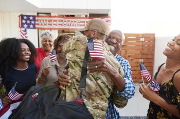 Millennial black soldier returning home to his family, embracing grandfather, back view