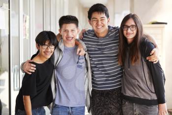 Portrait Of Smiling Male College Student Friends In Corridor Of Building