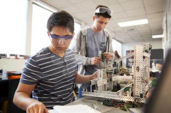 Two Male College Students Building Machine In Science Robotics Or Engineering Class